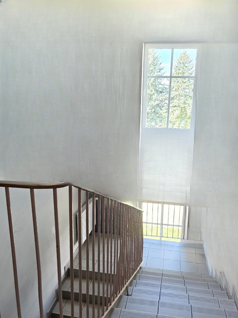 Schody wewnętrzne z balustradą i dużym oknem z widokiem na drzewa – Noclegi Gorzów w Baczynie